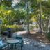 Seahorse Cottages on Sanibel adults-only courtyard with patio table, chairs, grill and lush tropical trees