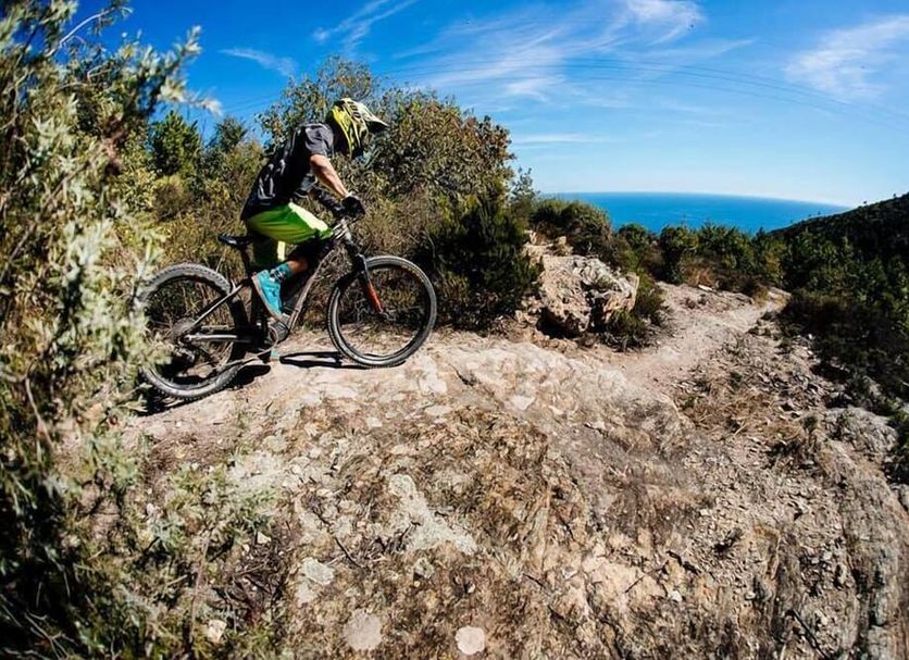 Hotel Maremola in Pietra Ligure with mountain biker on rocky trail and sea view