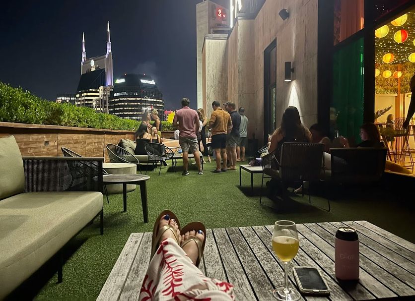 Fairlane Hotel Nashville rooftop lounge with city skyline view and guests seated outdoors at night