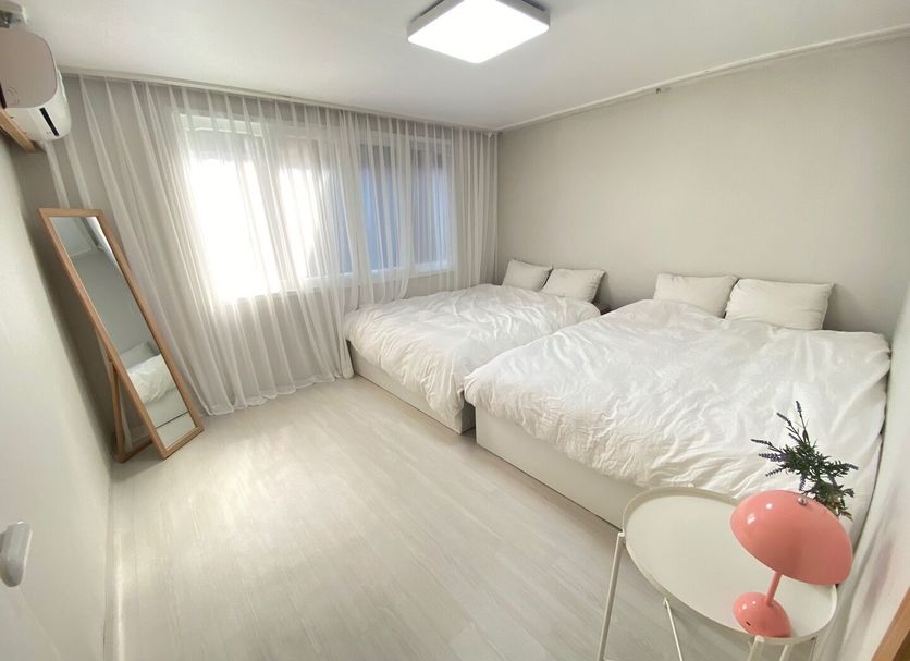 High Street Guest House Seoul room with two beds, window curtains and floor mirror