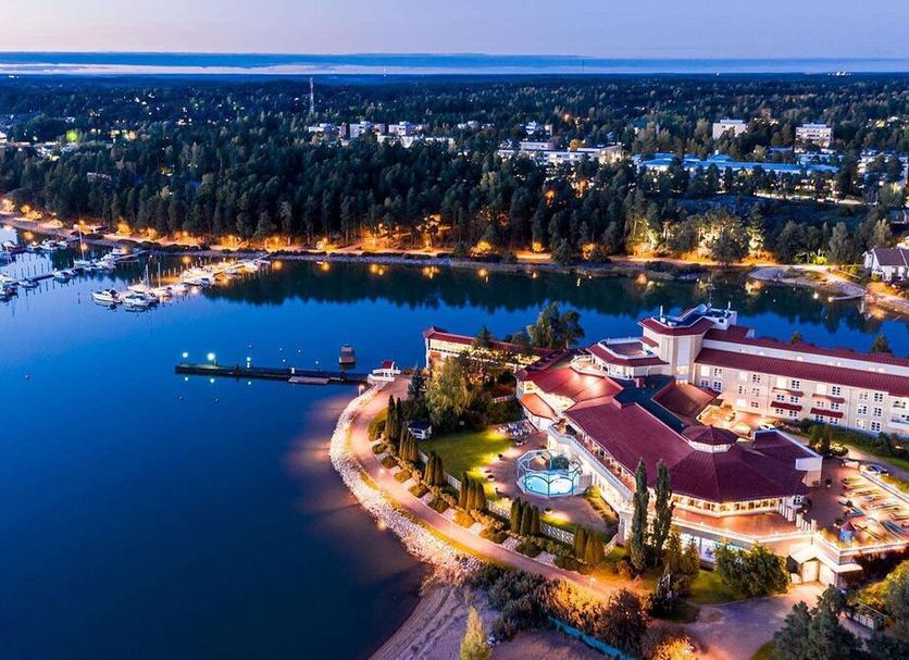 Naantali Spa Hotel in Naantali with bayfront view, marina, and illuminated spa building at dusk