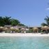 Fun Holiday Beach Resort in Negril with white-sand beach, turquoise water, and thatched umbrellas