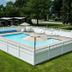 Nader's Motel & Suites in Ludington: outdoor pool with white fence, umbrellas and lounge chairs