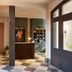 Hotel Anna & Bel lobby in Philadelphia with checkered tile floor, wood doors, and amber chandelier