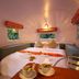 Mari Pai Resort in Pai: cozy curved room with a large bed, windows, and built-in bench seating