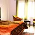 Hotel The Great Ananda in Haridwar guest room with bed, chairs, and bright window