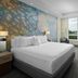 Courtyard by Marriott Delray Beach guest room with king bed, mural wall, and large window view in Coral Springs