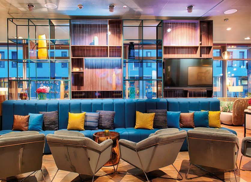 Nyx Hotel Munich By Leonardo Hotels lobby lounge with teal sofa and armchairs in Munich