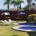 Hotel Cascada in Cuautla with outdoor pool, sun loungers, umbrellas, and palm-lined garden