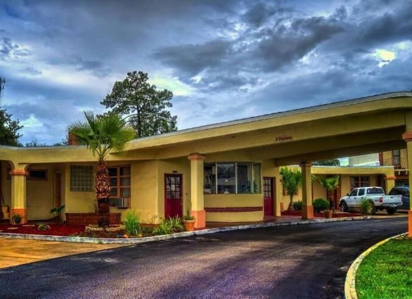 Nassau Holiday Motel in Yulee, exterior view with covered drive-up entrance and parked cars