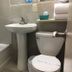 Diamond View Motel Susanville bathroom with tub, pedestal sink, toilet and shelf of towels