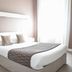 Hôtel L'Europe in Cholet: bright guest room with double bed, nightstand, and window light