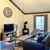 Bramblebank Cottages in Harrison Hot Springs, cozy living room with fireplace, sofa, TV, and window