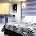 Retreat At Crystal Manatee room in Crystal River with striped accent wall and tropical-patterned bedspread