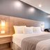 Hotel Marineau Shawinigan guest room with king bed, seating area and balcony doors in Shawinigan