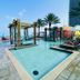 Lyfe Resort And Residences in Hollywood: rooftop pool with cabanas, palm trees, and ocean view