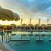 Hotel Panoramic in Caorle: outdoor pool at sunset with sea view and umbrellas