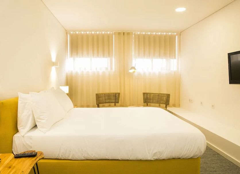 Bo - Álvares Cabral Guesthouse in Porto with a bright minimalist double bed and window seating area