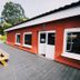 Arena Surf Hotel in Somo with outdoor picnic tables on a paved terrace beside an orange building