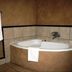Oak Rest Guesthouse, Kimberley: corner bathtub with tiled surround and hanging white towels