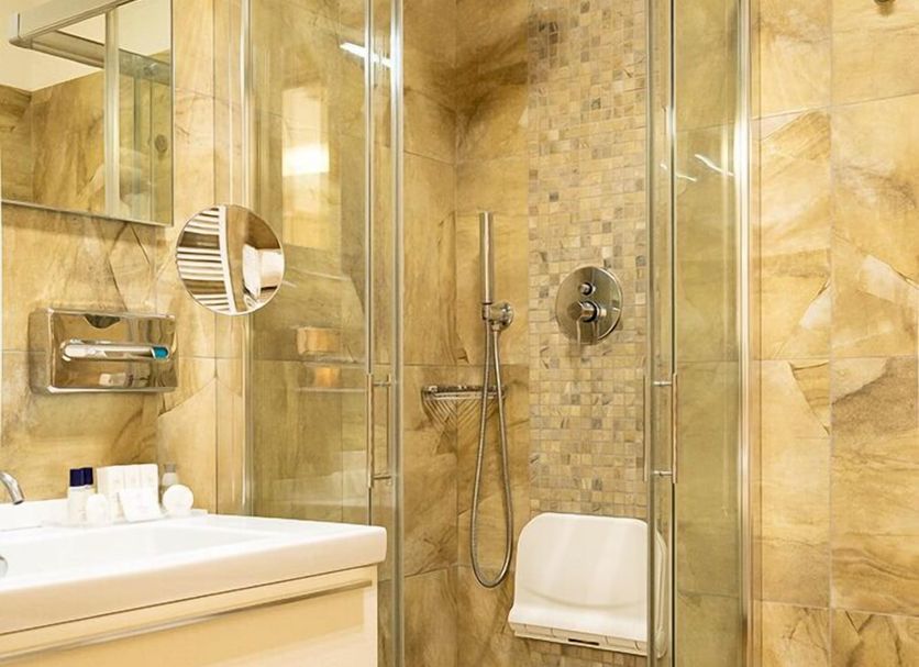 Hotels Vidi Miramare & Delfino Jesolo bathroom with glass-enclosed shower and marble tile walls