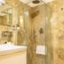 Hotels Vidi Miramare & Delfino Jesolo bathroom with glass-enclosed shower and marble tile walls