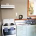 Kiwi's Nest Budget Accommodation & Backpackers kitchen with stove, sink, fridge and window in Dunedin