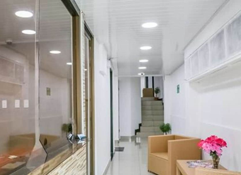 Hotel Casanova in San José hallway with seating area, staircase, and bright ceiling lights