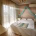Panamare Apart Hotel Akyaka bedroom with canopy bed, balcony doors and wardrobe in Akyaka