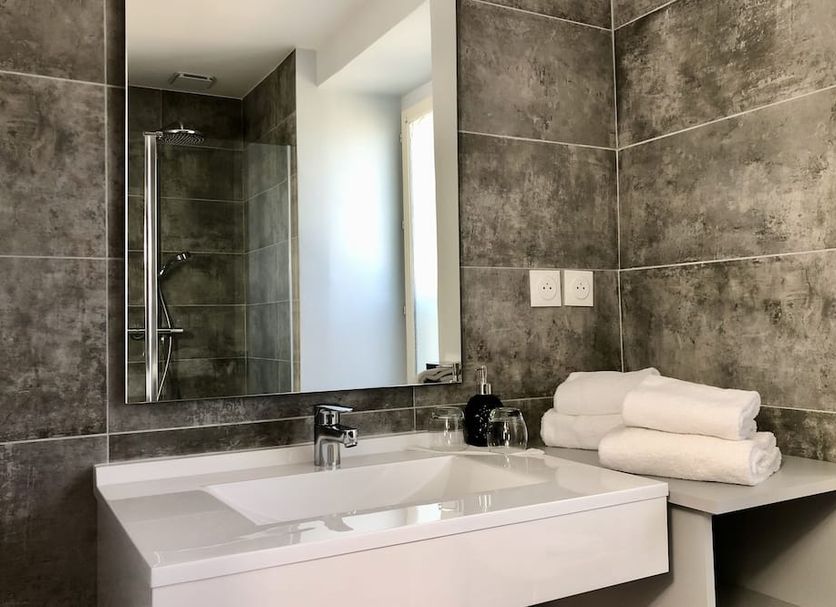 Auberge La Fontaine Aux Bretons in Pornic, modern bathroom with double sink, tiled shower and towels