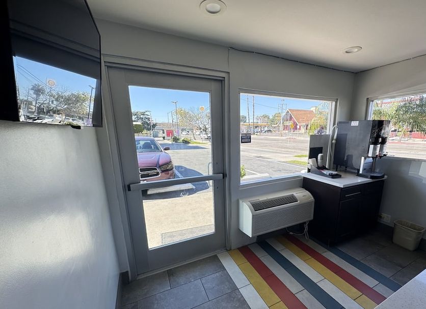 Motel 6 Ontario Airport lobby with glass entrance doors and street view in Ontario