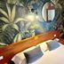 Hotel Al Sole Bardolino bedroom with tropical leaf wallpaper, wood headboard and wardrobe