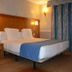 Hostal la Font guest room in Os de Civís with double bed, bedside lamps and striped curtains