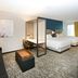 SpringHill Suites by Marriott Seattle Issaquah room with king bed, sofa, desk, and second bed