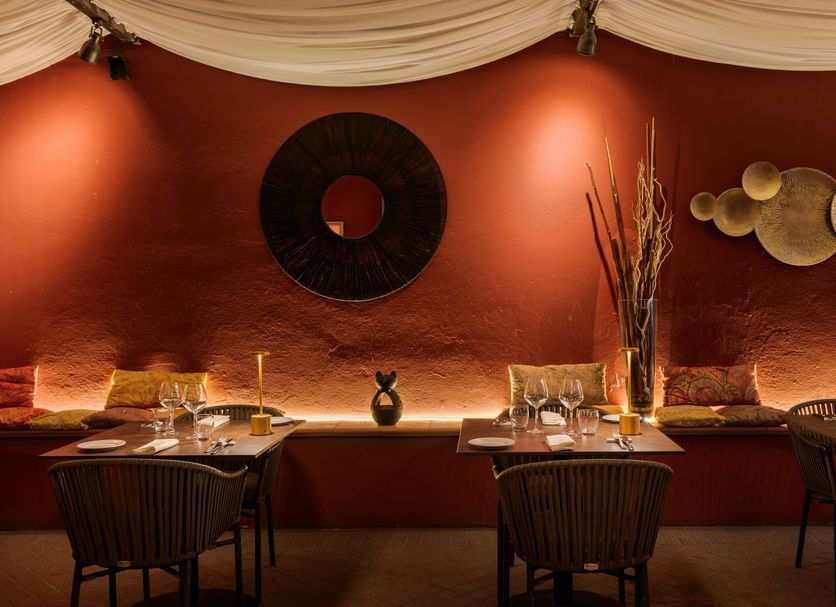 Hotel Dei Cavalieri Caserta dining room with warm red walls, candlelit tables, and decorative wall art