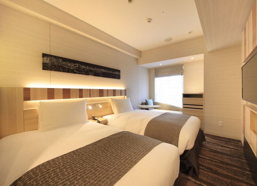 Hotel Sunroute Ginza, Tokyo guest room with two twin beds and a bright window seating area