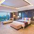 The St. Regis Mumbai guest room with king bed, seating area and city skyline view