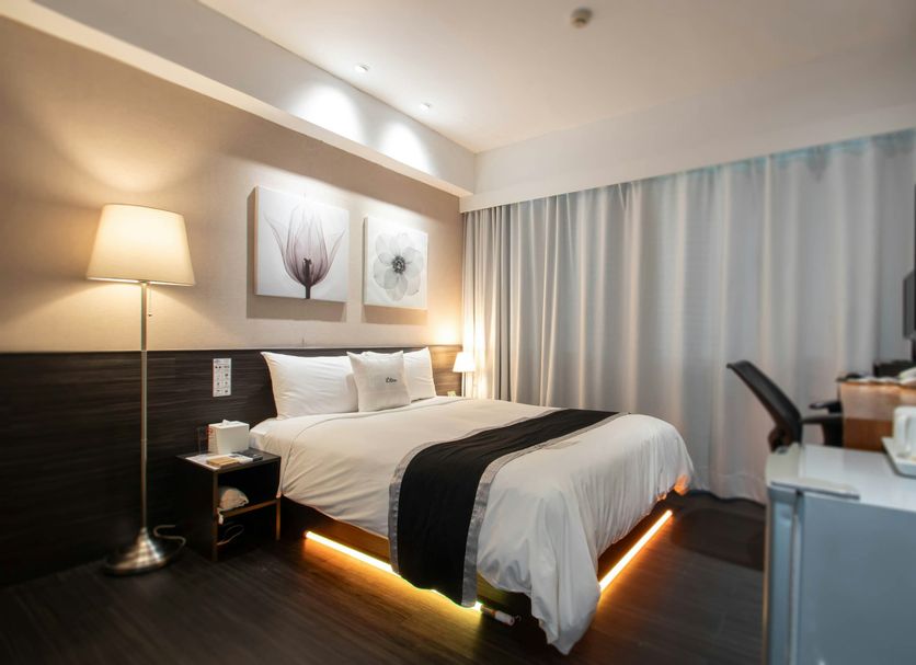 Stay Inn Taipei City room with king bed, floor lamp, desk, TV and curtain-covered window