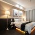 Stay Inn Taipei City room with king bed, floor lamp, desk, TV and curtain-covered window