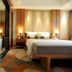 Wuzhou Guest House Shenzhen guest room with king bed, bedside lamps, and glass-walled bathroom
