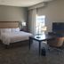 Hampton Inn Mcpherson room with king bed, desk, chair, TV, and window view in McPherson