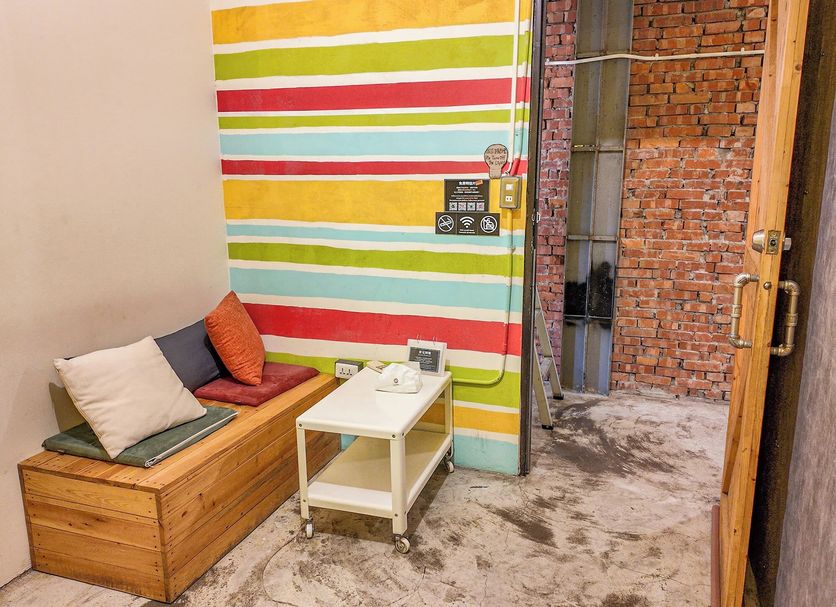 Lane62 Hostel Taichung City room with colorful striped accent wall, bench seat and small table