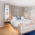 Cambria Hotel Waco University Riverfront guest room with king bed, bench, and blue area rug in Waco