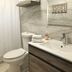 The Beach Guesthouse La Torre bathroom with shower, toilet, sink, towels and wall shelf