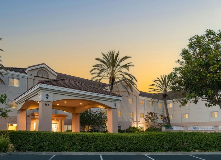 Fairfield Inn & Suites by Marriott San Francisco San Carlos exterior at sunset with palm trees and lit entrance