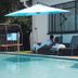 The Royal Princess Garden - Randburg poolside lounge with umbrella beside the outdoor pool