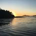 Cobble Wood and Bird Sanctuary Guest Houses in Tofino with sunset over calm ocean and wooded islands