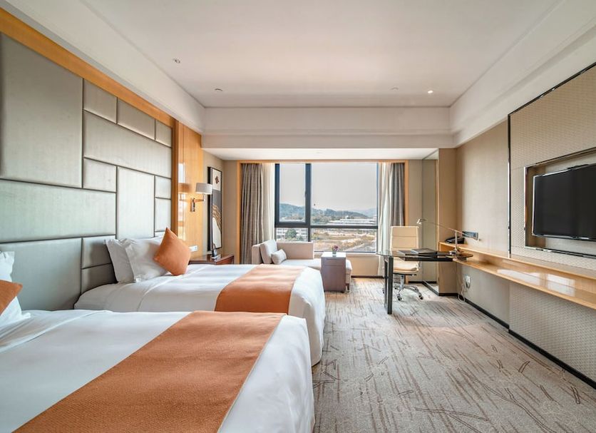 Swissôtel Guangzhou guest room with twin beds, desk, and city view