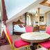 Royal Gdansk in Gdansk: spacious duplex room with staircase, round table, and red chairs