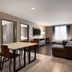 La Quinta Inn & Suites by Wyndham Montgomery suite with dining table, sofa, TV, and large window